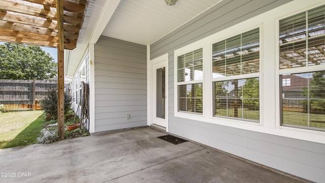 view of patio with fence and a porch