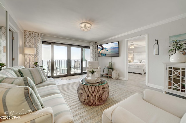 living area with wood finished floors, crown molding, and baseboards