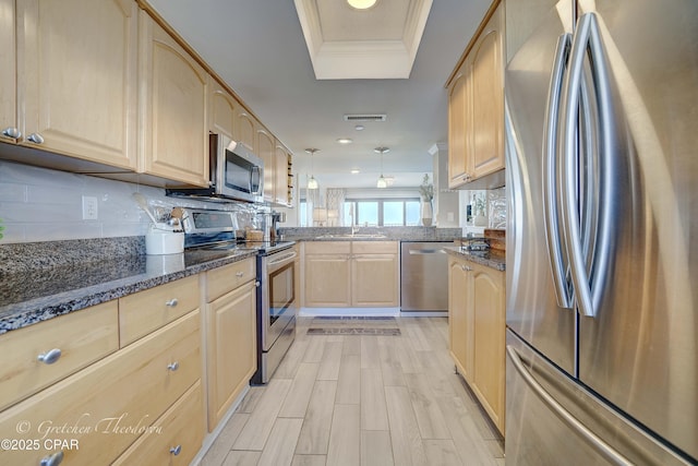 kitchen with light brown cabinetry, stainless steel appliances, dark stone countertops, backsplash, and visible vents