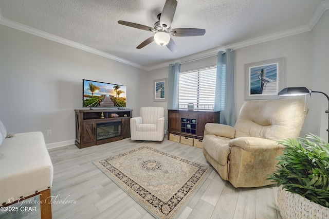 living room with ceiling fan, ornamental molding, wood finished floors, and a textured ceiling