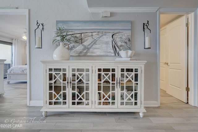 details featuring wood finish floors, ornamental molding, and baseboards