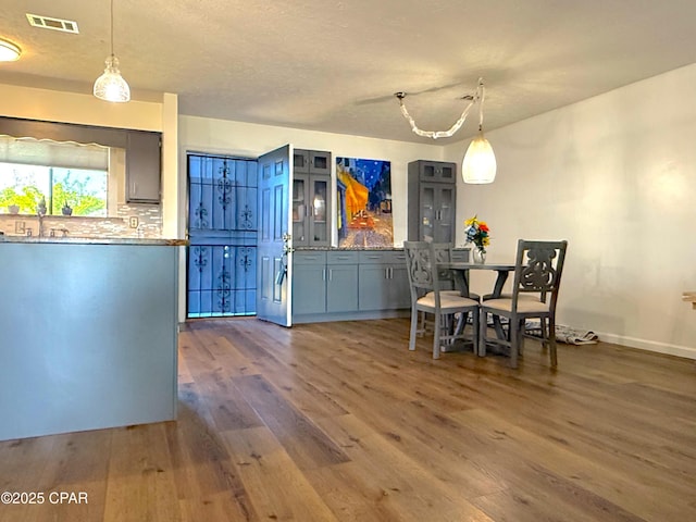 312 Sukoshi Dr, Panama City, FL 32404 - dining space featuring visible vents, baseboards, wood finished floors, and a textured ceiling