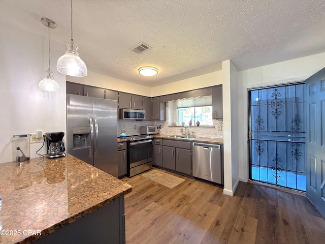 312 Sukoshi Dr, Panama City, FL 32404 - kitchen with stainless steel appliances, visible vents, a sink, decorative backsplash, and light wood-style flooring