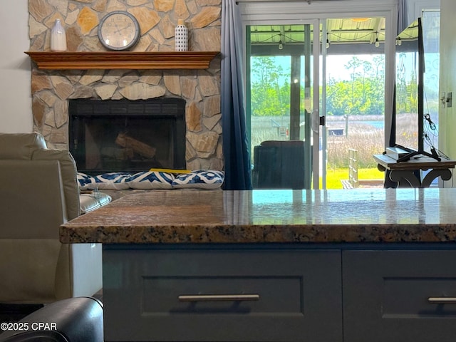 312 Sukoshi Dr, Panama City, FL 32404 - kitchen featuring a stone fireplace, gray cabinetry, and dark stone countertops