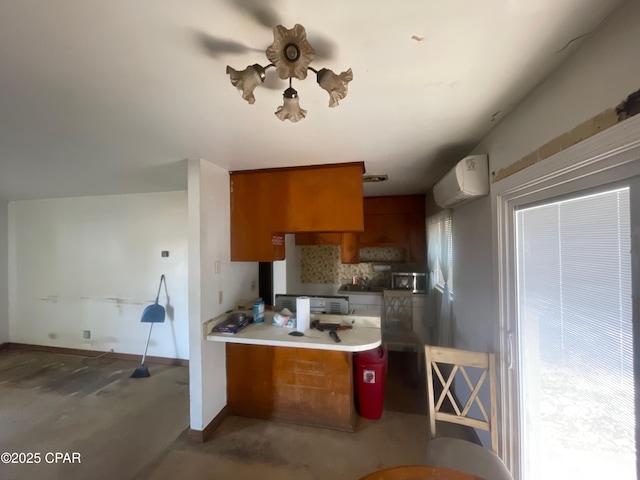609 Bob Little Rd, Panama City, FL 32404 - kitchen featuring a peninsula, brown cabinets, ceiling fan, a wall unit AC, and baseboards