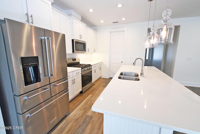 3116 Veranda Ave, Panama City, FL 32405 - kitchen with recessed lighting, stainless steel appliances, a sink, light wood-type flooring, and a kitchen island with sink