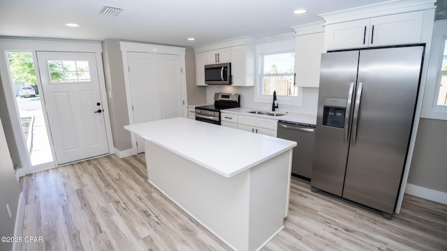 6401 Chipewa St, Panama City, FL 32404 - kitchen with a kitchen island, white cabinets, visible vents, appliances with stainless steel finishes, and a sink