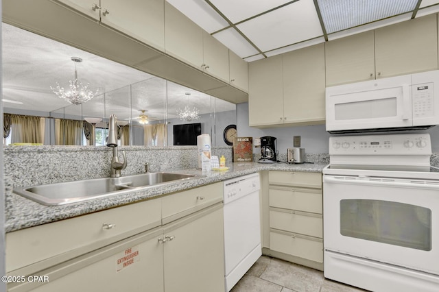 520 Richard Jackson Blvd Unit 2005, Panama City Beach, FL 32407 - kitchen with an inviting chandelier, white appliances, cream cabinetry, a sink, and light tile patterned floors