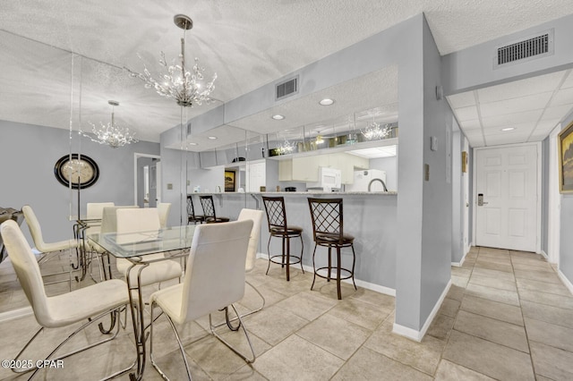 520 Richard Jackson Blvd Unit 2005, Panama City Beach, FL 32407 - dining area featuring baseboards, a notable chandelier, a textured ceiling, and visible vents