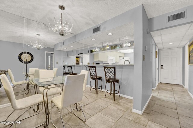 520 Richard Jackson Blvd Unit 2005, Panama City Beach, FL 32407 - dining area featuring baseboards, a notable chandelier, a textured ceiling, and visible vents