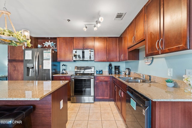 kitchen with a sink, light tile patterned floors, stainless steel appliances, light stone countertops, and visible vents