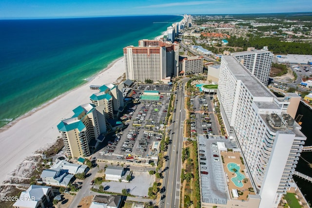 drone / aerial view featuring a beach view, a city view, and a water view