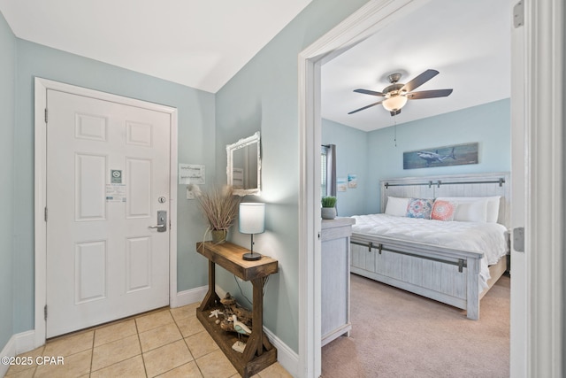 tiled foyer featuring baseboards and ceiling fan