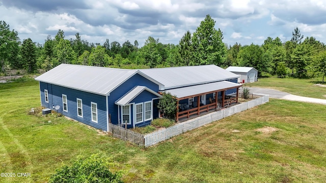 exterior space featuring central air condition unit, a porch, metal roof, and a front yard