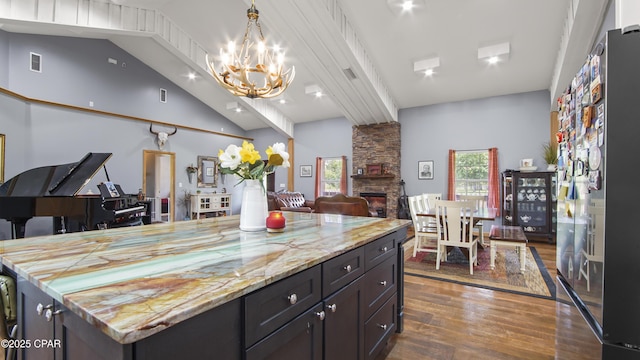 10583 State Road 20, Clarksville, FL 32430 - kitchen featuring a stone fireplace, dark wood finished floors, open floor plan, an inviting chandelier, and vaulted ceiling with beams