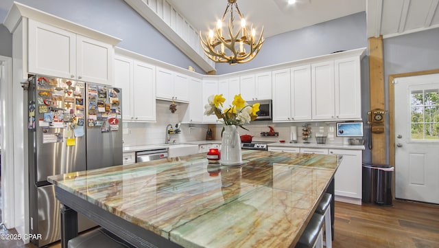 kitchen with backsplash, stainless steel appliances, a chandelier, and a sink
