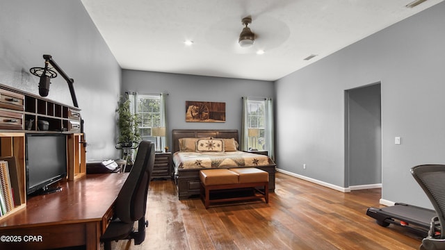bedroom featuring wood-type flooring, a ceiling fan, baseboards, and visible vents