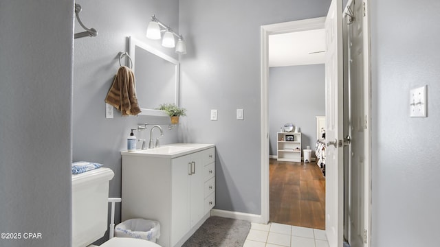 bathroom featuring vanity, tile patterned flooring, baseboards, and toilet