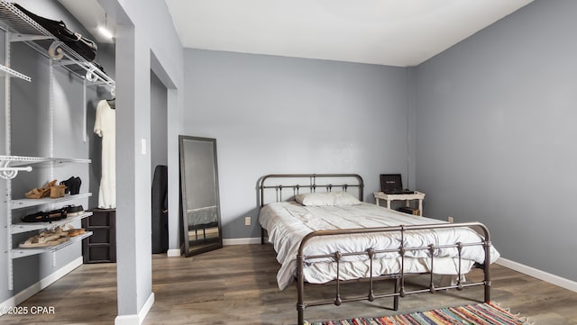 bedroom featuring baseboards and wood finished floors