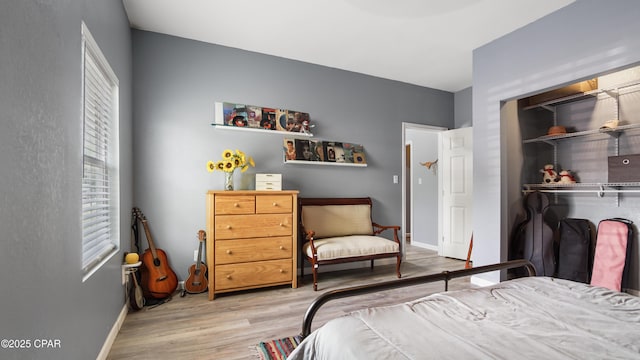 bedroom with baseboards, a closet, and wood finished floors