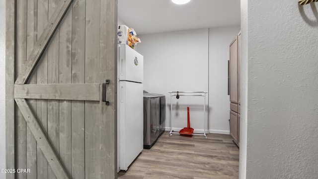 interior space featuring laundry area, wood finished floors, and washing machine and clothes dryer