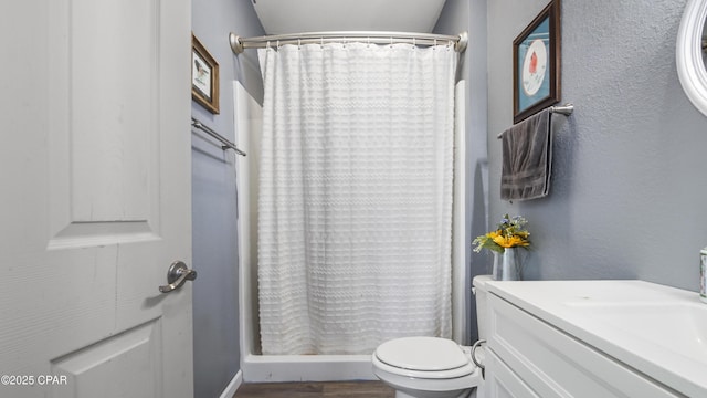 bathroom featuring vanity, toilet, wood finished floors, and a shower with shower curtain