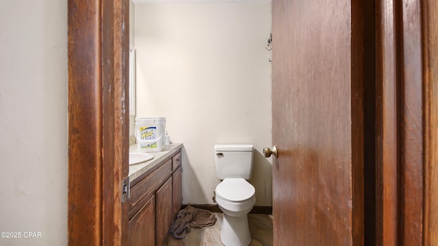 half bath featuring vanity and toilet