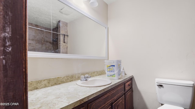 bathroom with toilet, vanity, and a shower
