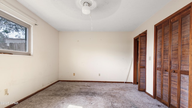 unfurnished bedroom featuring a ceiling fan, baseboards, and carpet floors