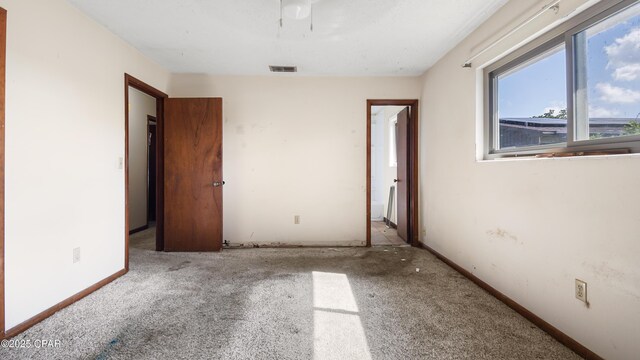 unfurnished bedroom with baseboards, visible vents, and carpet