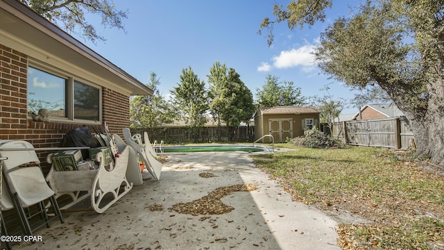 view of yard with a storage unit, a fenced in pool, a fenced backyard, a patio area, and an outdoor structure
