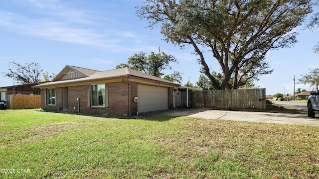 view of side of property featuring fence, concrete driveway, an attached garage, a lawn, and brick siding