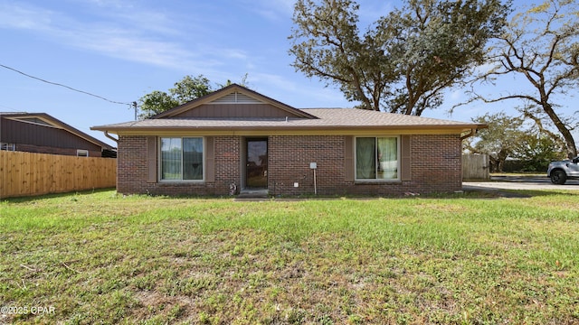 bungalow-style home featuring fence, a front lawn, and brick siding