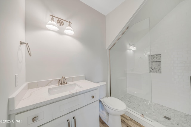 309 Paridiso Pl Unit A, Panama City Beach, FL 32413 - full bathroom with toilet, tiled shower, vanity, and wood finished floors