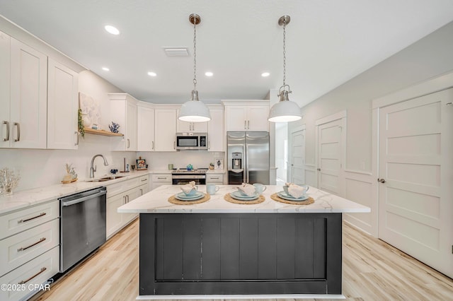 309 Paridiso Pl Unit A, Panama City Beach, FL 32413 - kitchen featuring appliances with stainless steel finishes, a sink, white cabinetry, light wood-type flooring, and recessed lighting