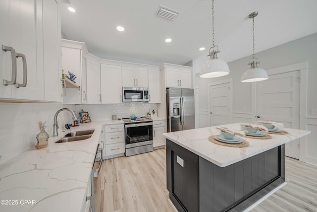 309 Paridiso Pl Unit A, Panama City Beach, FL 32413 - kitchen featuring stainless steel appliances, a sink, light wood-style flooring, tasteful backsplash, and recessed lighting