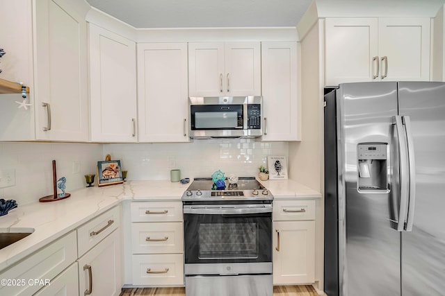 309 Paridiso Pl Unit A, Panama City Beach, FL 32413 - kitchen with appliances with stainless steel finishes, decorative backsplash, and white cabinets