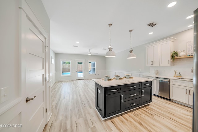 309 Paridiso Pl Unit A, Panama City Beach, FL 32413 - kitchen featuring stainless steel dishwasher, dark cabinets, white cabinetry, light countertops, and a wainscoted wall