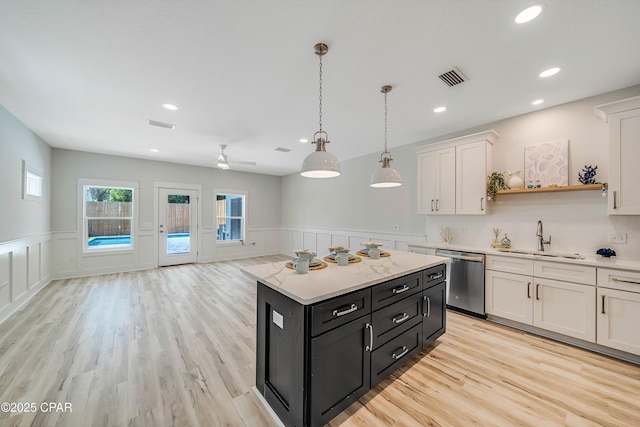 309 Paridiso Pl Unit A, Panama City Beach, FL 32413 - kitchen featuring dishwasher, a sink, white cabinets, dark cabinetry, and a wainscoted wall