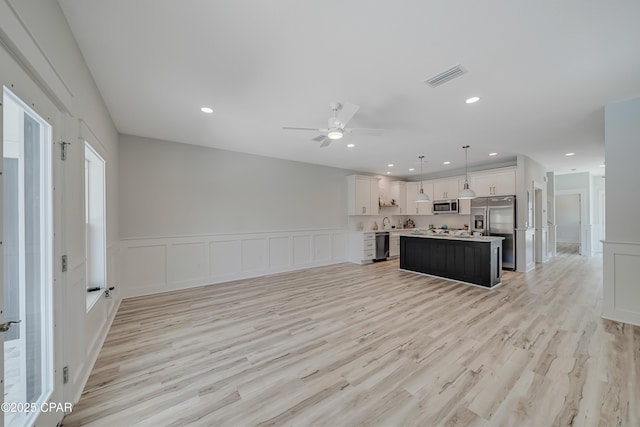 309 Paridiso Pl Unit A, Panama City Beach, FL 32413 - kitchen featuring stainless steel appliances, open floor plan, light wood-type flooring, light countertops, and a center island