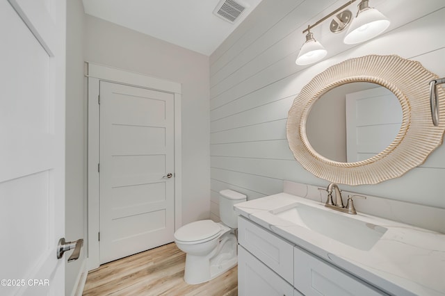309 Paridiso Pl Unit A, Panama City Beach, FL 32413 - bathroom with vanity, toilet, wood finished floors, and wooden walls
