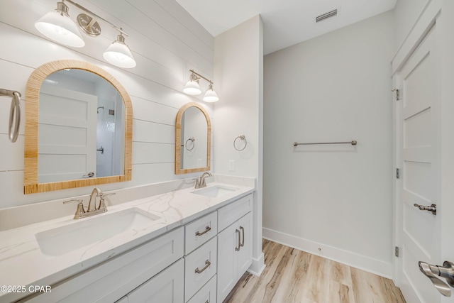 309 Paridiso Pl Unit A, Panama City Beach, FL 32413 - full bath with double vanity, wood finished floors, wooden walls, and baseboards