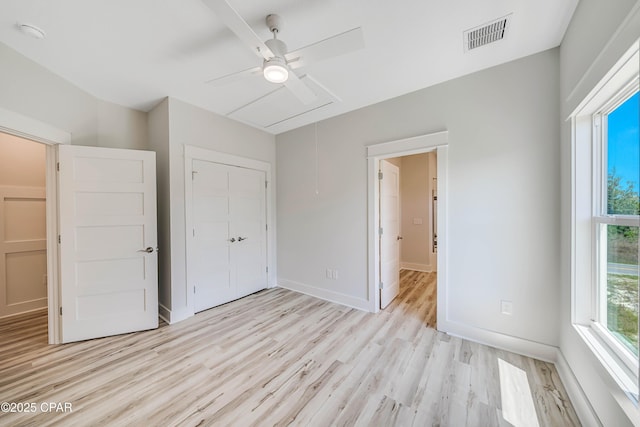 309 Paridiso Pl Unit A, Panama City Beach, FL 32413 - unfurnished bedroom featuring attic access, light wood-style floors, baseboards, a closet, and a ceiling fan