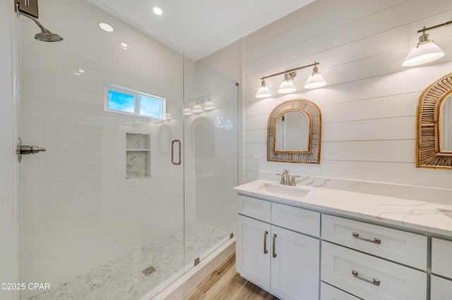 309 Paridiso Pl Unit A, Panama City Beach, FL 32413 - bathroom with a stall shower, double vanity, and wood finished floors