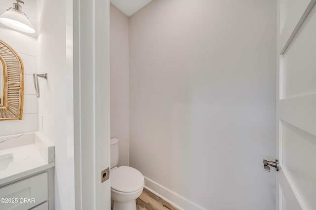 309 Paridiso Pl Unit A, Panama City Beach, FL 32413 - bathroom with toilet, vanity, wood finished floors, and baseboards