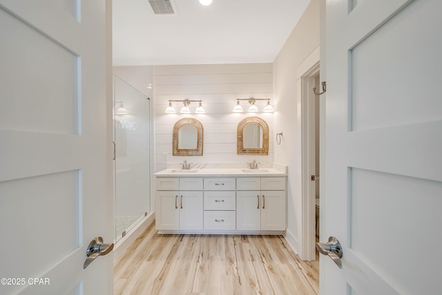 309 Paridiso Pl Unit A, Panama City Beach, FL 32413 - bathroom featuring double vanity, wood finished floors, a stall shower, and toilet