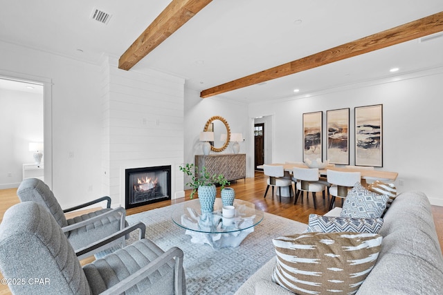 1502 Match Point Ln Unit 402, Panama City Beach, FL 32413 - living area featuring beam ceiling, wood finished floors, a large fireplace, ornamental molding, and recessed lighting