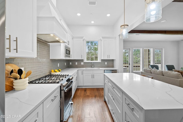 1502 Match Point Ln Unit 402, Panama City Beach, FL 32413 - kitchen featuring appliances with stainless steel finishes, custom exhaust hood, open floor plan, dark wood finished floors, and backsplash