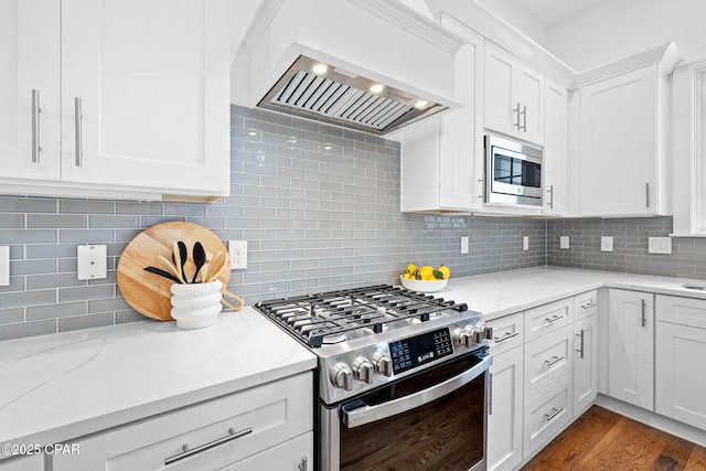 1502 Match Point Ln Unit 402, Panama City Beach, FL 32413 - kitchen featuring appliances with stainless steel finishes, custom exhaust hood, backsplash, and white cabinets