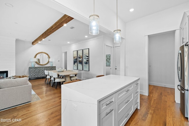 1502 Match Point Ln Unit 402, Panama City Beach, FL 32413 - kitchen with freestanding refrigerator, open floor plan, white cabinetry, hanging light fixtures, and light wood-style flooring